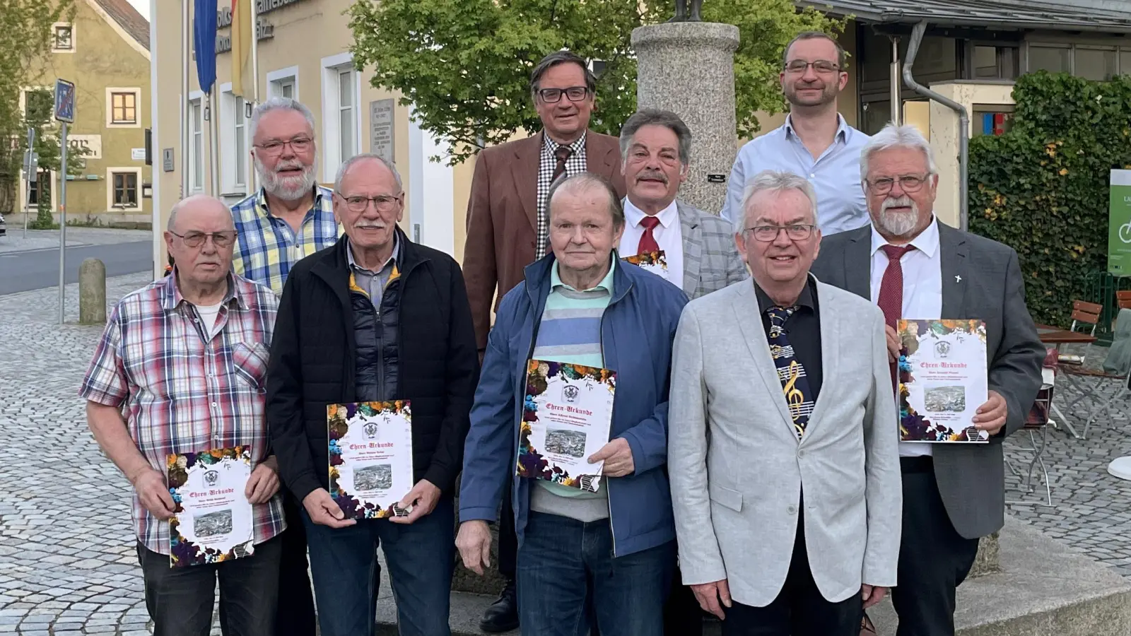 Vor dem gemütlichen Beisammensein: Gruppenfoto mit den Geehrten vor dem Gänselieselbrunnen auf dem Marktplatz in Luhe (Bild: Lutz Hengge)