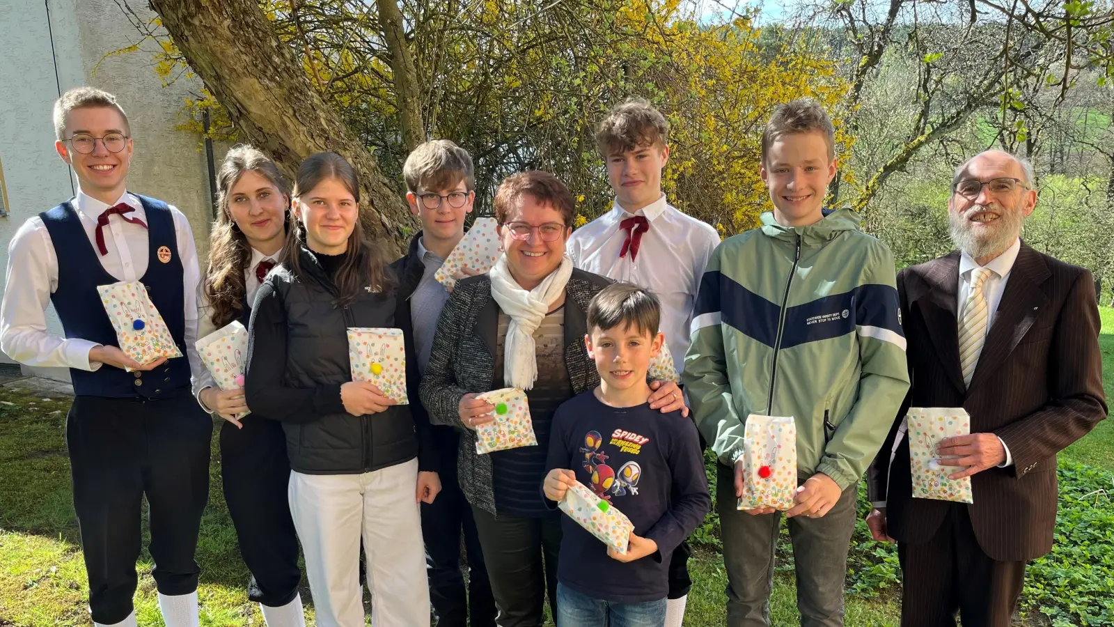 Große Freude bei den Ministranten der Pfarrei Unterauerbach, nachdem die Osterüberraschung gelungen war. Zusammen mit Pfarrer Josef Dotzler (rechts) und Kirchenpflegerin Renate Pusch (Mitte) machten sie sich im Pfarrgarten auf die Suche nach den Osternestern. (Bild: Franz Grabinger)